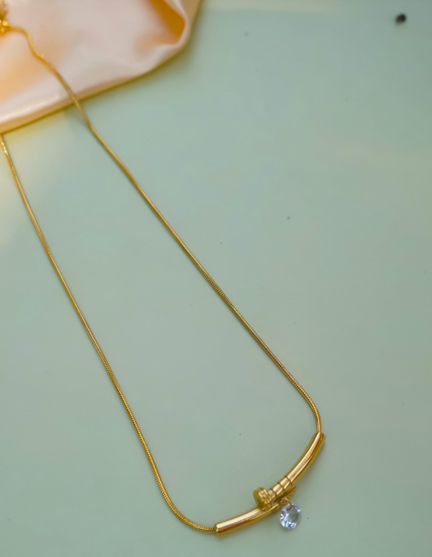 18k goldplated Stainless steel chain with nail shaped pendant and a diamond hanging