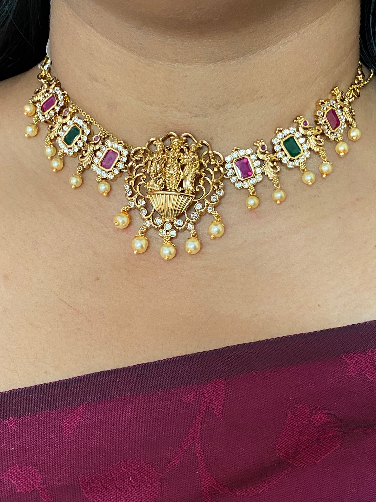 LuxeHara Ram Parivar Choker along with earrings with added red and green stones and hanging pearls.